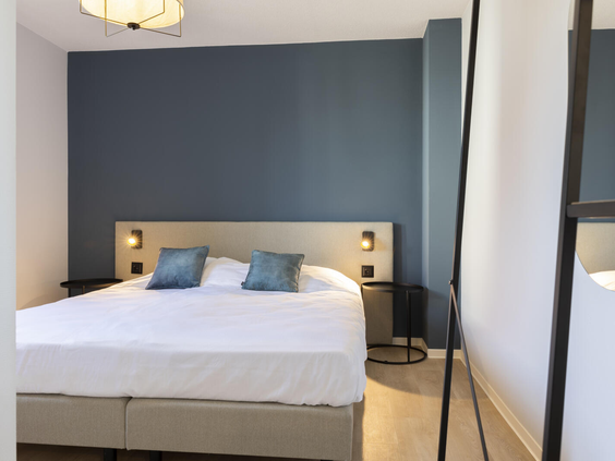 Een modern ingerichte, rustige slaapkamer met een comfortabel opgemaakt tweepersoonsbed in een vakantiewoning op Dormio Resort Nieuwvliet-Bad.