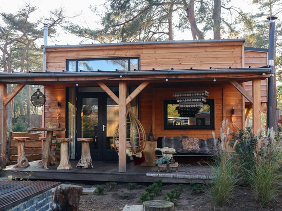 Houten tiny house op Droompark De Zanding, gelegen in de natuur met een gezellige veranda, ideaal voor een vakantie op de Veluwe.