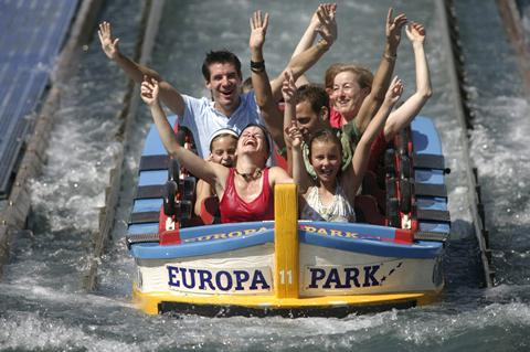 Een lachende familie met de handen in de lucht in een wildwaterbaan (boomstamattractie) in Europa-Park.