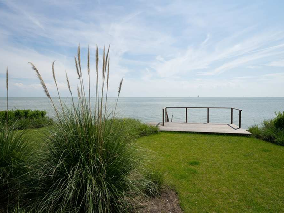 Een houten vlonder aan de waterkant op EuroParcs Markermeer, een perfecte plek om te vissen of te genieten van het uitzicht over het Markermeer.