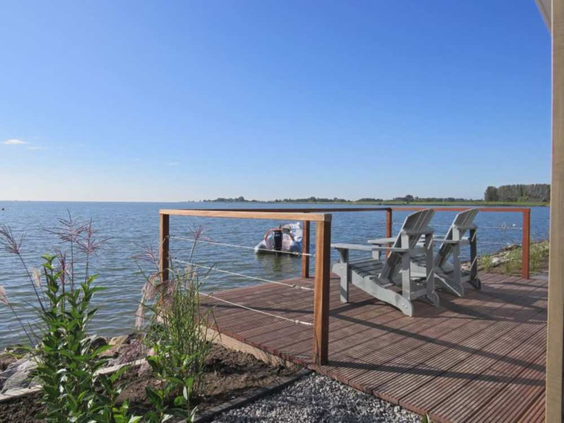 Houten vlonder met comfortabele stoelen en een prachtig uitzicht over het Markermeer op vakantiepark EuroParcs Markermeer.