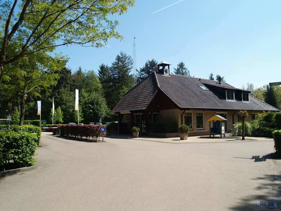 Het restaurant met een ruim en zonnig terras op EuroParcs Resort De Utrechtse Heuvelrug, omringd door groene bomen.