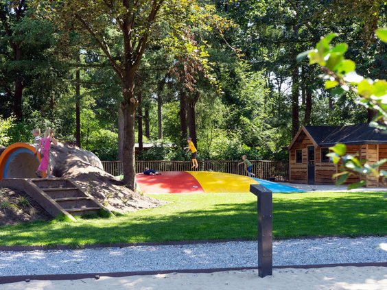 Een kleurrijke airtrampoline en een glijbaan in de buitenspeeltuin van EuroParcs Resort De Utrechtse Heuvelrug.