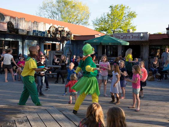 Kinderen en het animatieteam dansen enthousiast mee tijdens de kinderdisco op het terras van EuroParcs Resort Limburg.
