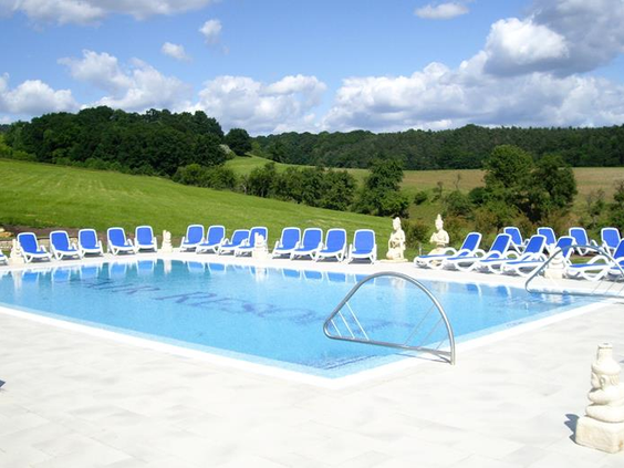 Het zonnige buitenzwembad van het FAIR Resort, omgeven door groene heuvels in de natuur van Thüringen.
