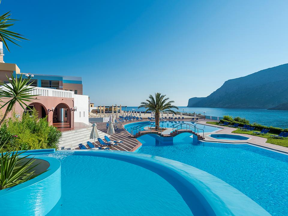 Het schitterende zwembad van Fodele Beach Resort op Kreta, met een adembenemend uitzicht over de helderblauwe zee.