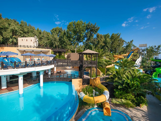 Het levendige waterpark van Fodele Beach Resort met diverse zwembaden, waterglijbanen en een zonneterras.