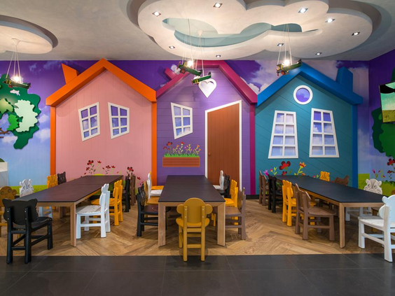 Het vrolijke interieur van de kidsclub bij Fodele Beach Resort op Kreta, met tafels, stoeltjes en muren in de vorm van kleurrijke huisjes.
