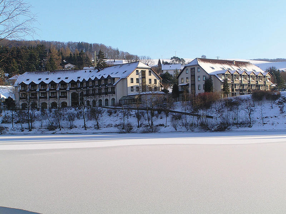 Het Göbels Seehotel, prachtig gelegen aan de bevroren Diemelsee in een winters landschap in Sauerland.