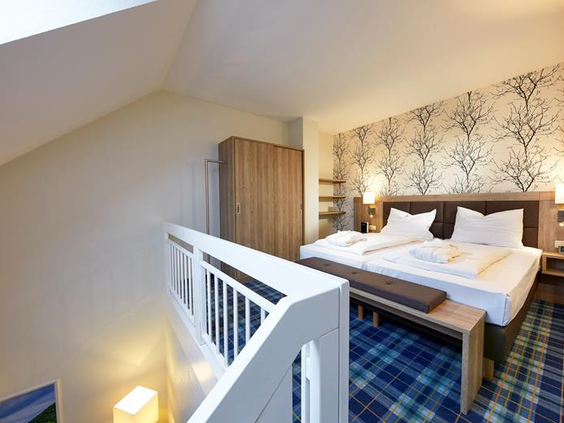 Het slaapgedeelte op de bovenverdieping van de maisonnette familiekamer in Göbels Seehotel Diemelsee.