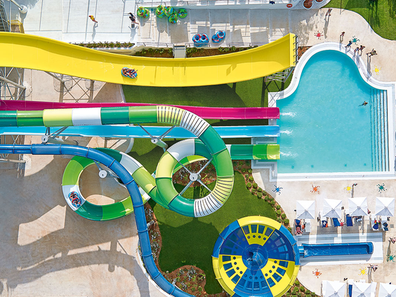 Luchtfoto van de vele kleurrijke en kronkelende waterglijbanen in het spectaculaire aquapark van Grecotel Club Marine Palace op Kreta.