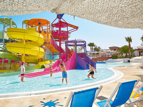 Overzicht van het kleurrijke aquapark 'Kingdom of Poseidon' bij Grecotel Club Marine Palace, vol met spectaculaire glijbanen en waterspeeltoestellen.