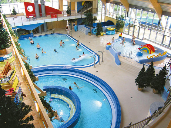 Overzicht van het zwemparadijs Brockenbad in Hasseröder Ferienpark, met een stroomversnelling, glijbaan en kinderbad.