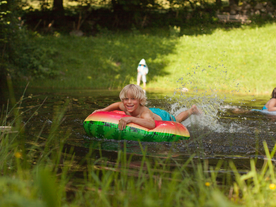 Kind dobbert op opblaasband in het meer bij Hilserhof Baden‑Württemberg veilig zwemmen en waterpret voor gezinnen
