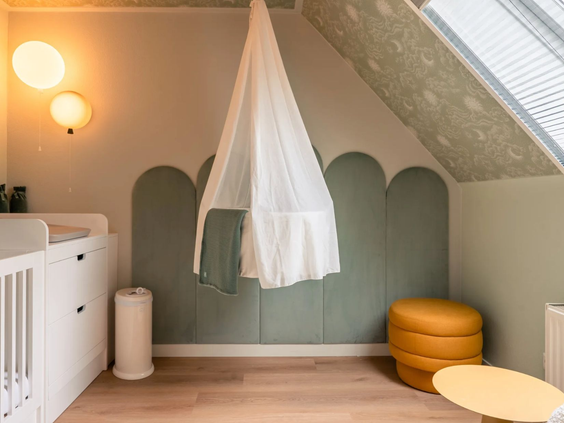 De sfeervol ingerichte babykamer in de Newborn boerderij op Hof van Saksen, voorzien van een ledikant, commode en een hangwiegje.