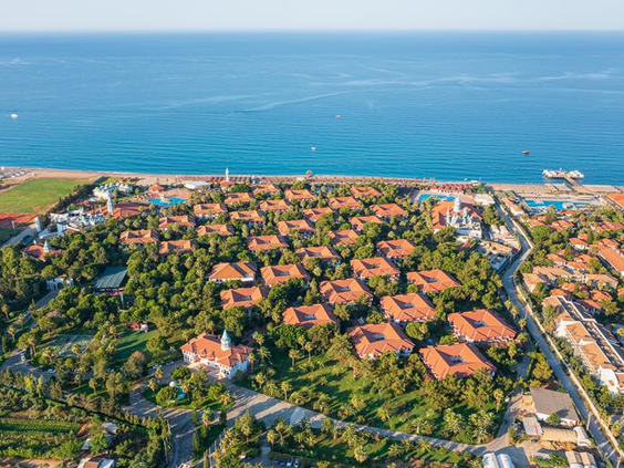 Luchtfoto van het uitgestrekte resort van Hotel Ali Bey Club, prachtig gelegen in het groen en direct aan de kust van Side, Turkije.