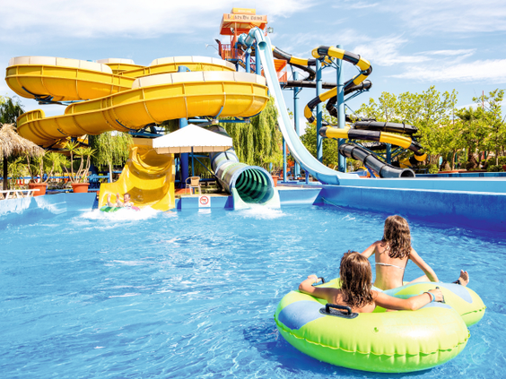 Kinderen drijven op een band in het waterpark van SPLASHWORLD Aqualand Village, meerdere glijbanen voor kinderen