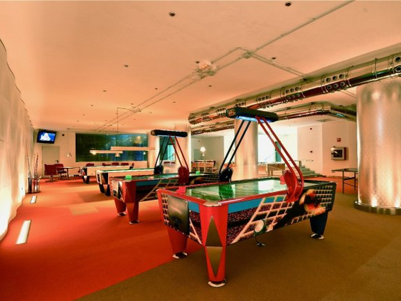 De gameroom van Hotel Eugenia Victoria met diverse speelautomaten en airhockeytafels.