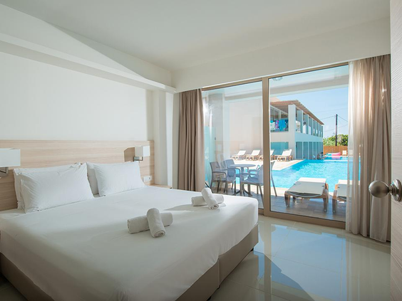 Luxe en lichte familiekamer met een opgemaakt tweepersoonsbed en een terras met directe toegang tot een gedeeld zwembad (swim-up).