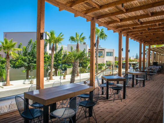 Overdekte beachbar met houten pergola en tafels bij Gouves Waterpark Holiday Resort Kreta