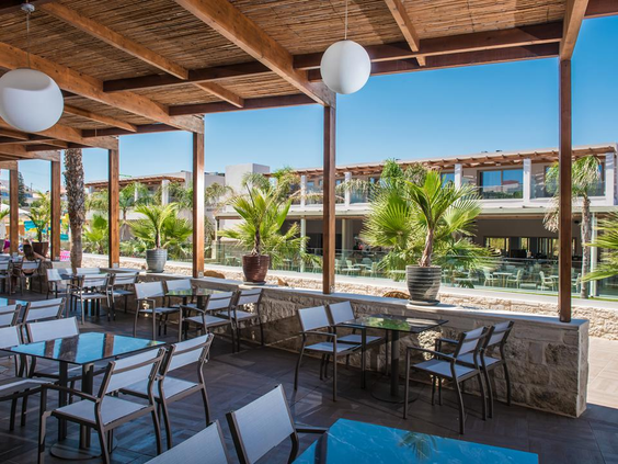 Overdekt restaurantterras met uitzicht op resort bij Gouves Waterpark Holiday Resort Kreta