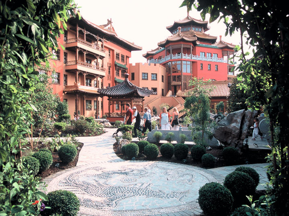 Prachtige, groene binnentuin van Hotel Ling Bao in Phantasialand, aangelegd in Aziatische stijl met een pad en Chinese pagodes.