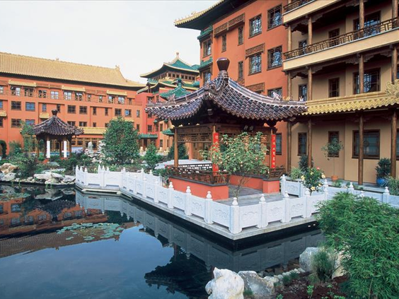 De serene binnenplaats van Hotel Ling Bao met een traditionele Chinese pagode in het midden van een vijver.