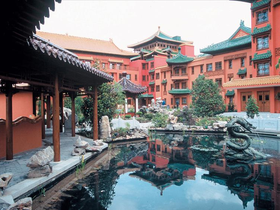 Rustgevende binnenplaats van Hotel Ling Bao, waar de Chinese architectuur weerspiegelt in de vijver met een stenen drakenbeeld.