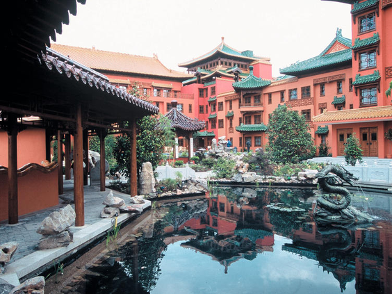 De rustgevende binnenplaats van Hotel Ling Bao met een vijver waarin de Chinese architectuur van het hotel weerspiegelt.