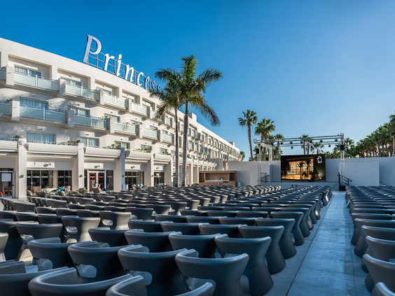 Het grote, openlucht amfitheater van Hotel Maspalomas Princess, met rijen zitplaatsen die gericht zijn op een podium voor avondentertainment.