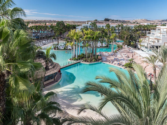 Een overzichtsfoto van het gigantische zwembadlandschap van Maspalomas Princess, met meerdere baden, eilandjes en een kunstmatig strand.