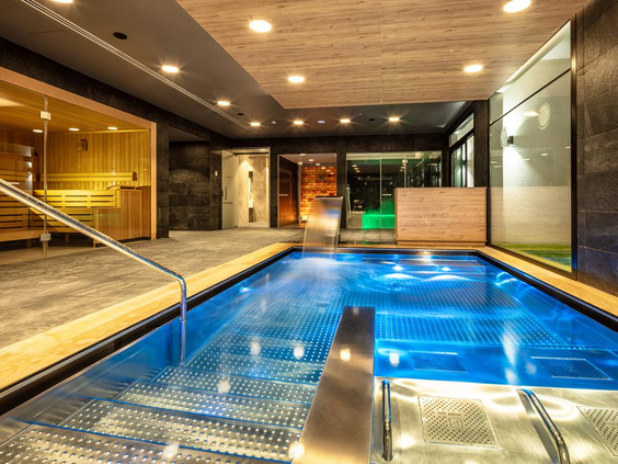 Het luxe binnenzwembad in de spa van Hotel Maspalomas Princess, met sfeervolle verlichting en een kleine waterval.