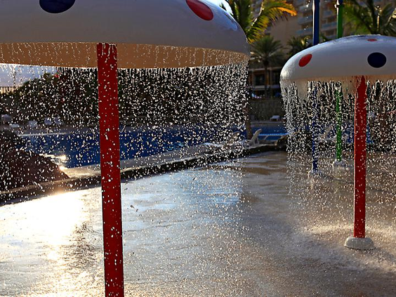 Een waterspeeltuin met paddenstoel-fonteinen en diverse watersproeiers waar kinderen kunnen spelen in Aquapark Lago Taurito.