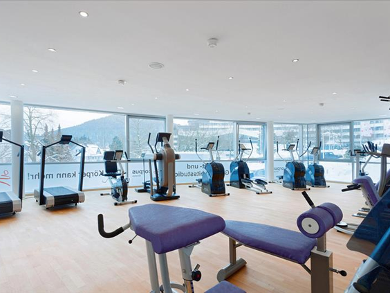 Lichte fitnessruimte in Hotel Sauerland Stern met diverse moderne cardio- en krachttoestellen en een groot raam met uitzicht naar buiten.