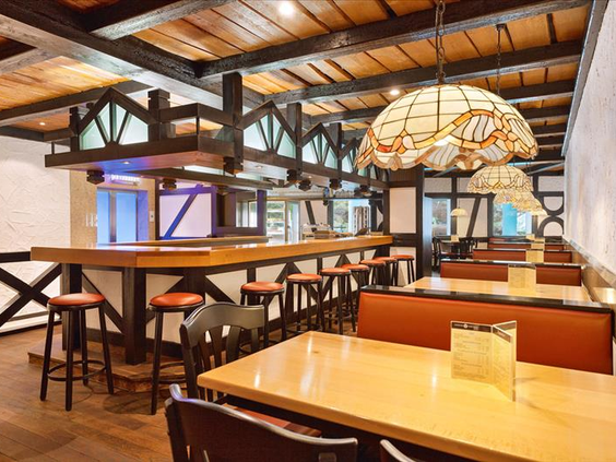 Het gezellige grillrestaurant in Hotel Sauerland Stern met een rustieke inrichting, houten tafels en een sfeervolle bar.
