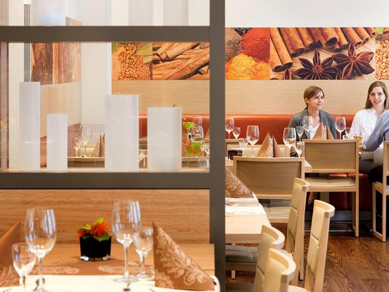 Het sfeervolle restaurant van het Ibis Hotel in Aken, waar gasten genieten van een maaltijd in een moderne setting.