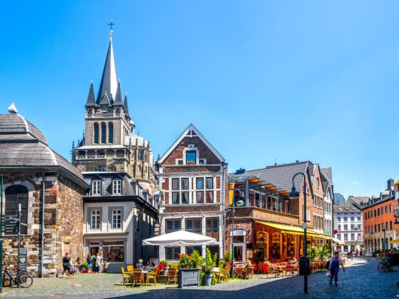 Een sfeervol straatbeeld in het historische centrum van Aken, met gezellige terrasjes en oude gebouwen, vlakbij het Ibis hotel.