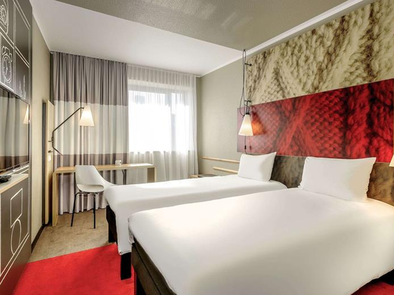 Een moderne en lichte familiekamer in het Ibis Hotel Aken met twee aparte bedden, ideaal voor een gezin met kinderen.
