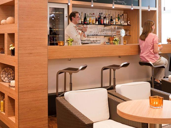 De gezellige hotelbar van het Ibis Hotel in Aken waar ouders kunnen ontspannen met een drankje en de kinderen een sapje.