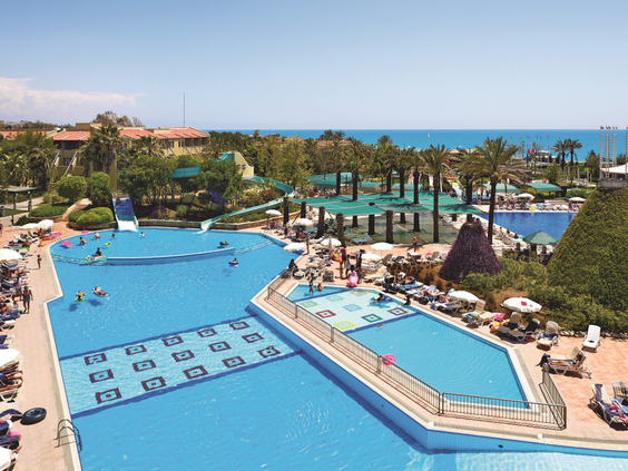 Overzicht van het enorme buitenzwembad van hotel Pegasos World in Side, Turkije, met uitzicht op zee.