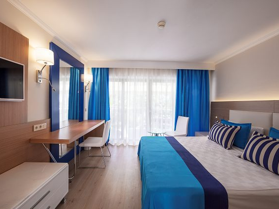 Een netjes ingerichte familiekamer in hotel Pegasos World in Side, Turkije, met blauwe en witte accenten.