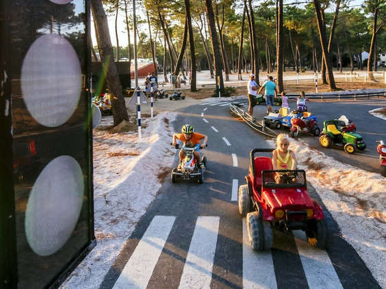 Kinderen rijden in elektrische autootjes in de mini-rijschool met verkeerslichten op het kindvriendelijke Zaton Holiday Resort.