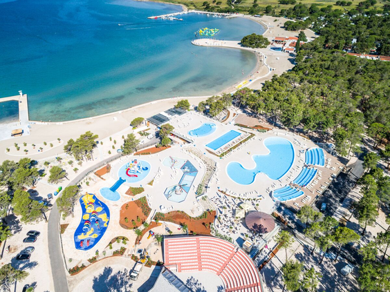 Luchtfoto van Zaton Holiday Resort met zowel het grote zwembadcomplex als het kindvriendelijke zandstrand aan de Adriatische kust in Kroatië.