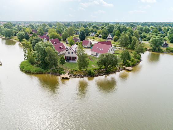Luchtfoto van Vakantiepark Sandur, waarop te zien is hoe de vakantiehuizen op unieke schiereilanden in de Grote Rietplas liggen.