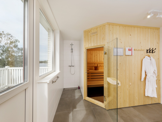Luxe badkamer in een wellness bungalow op Vakantiepark Sandur, voorzien van een ruime douche en een privé sauna.