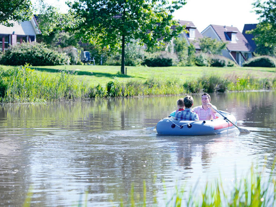 Gezin vaart in een bootje op de Grote Rietplas bij Vakantiepark Sandur in Drenthe.