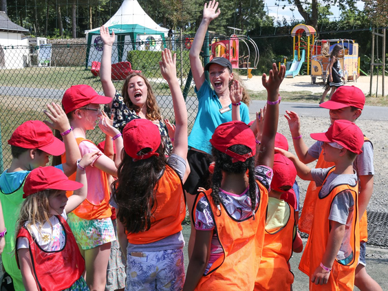 Enthousiast animatieteam met een groep lachende kinderen in de miniclub op de kindvriendelijke camping Domaine des Ormes.