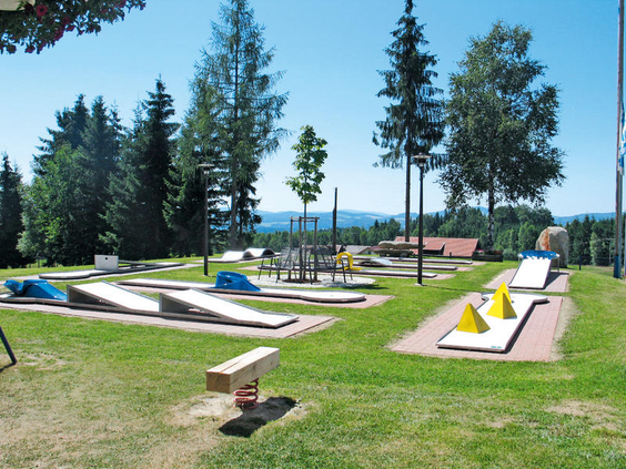 De uitdagende midgetgolfbaan van KNAUS Campingpark Lackenhäuser, gelegen in een heuvelachtig en groen landschap.