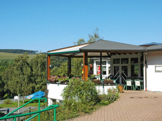 Het terras van het restaurant op KNAUS Campingpark Lackenhäuser, met een weids uitzicht over het heuvelachtige Beierse landschap.