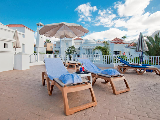 Overzicht van het grote zwembad in rivierstijl, omringd door ligbedden en parasols, perfect voor gezinnen.